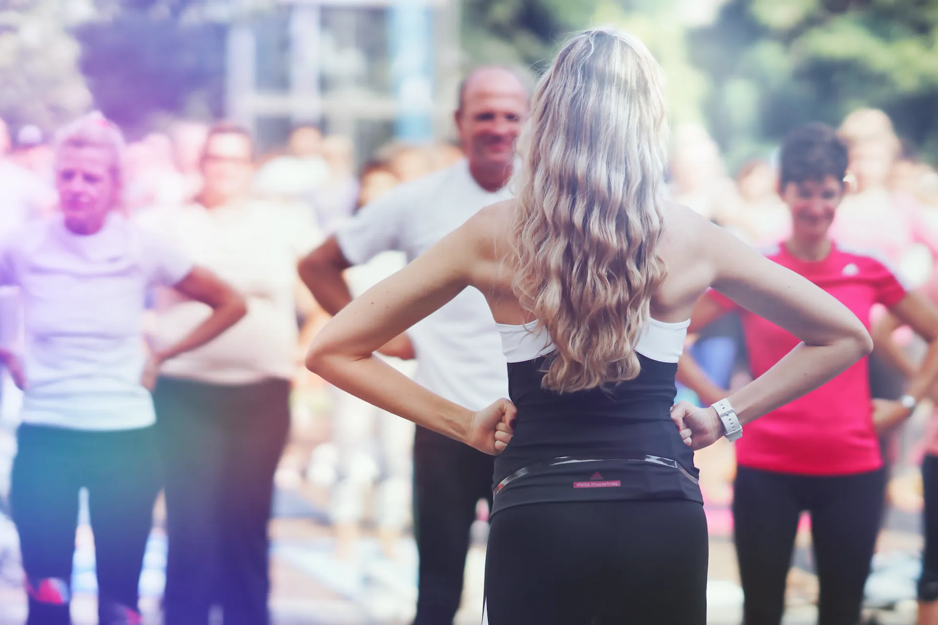 Suzanne von hinten, Haende in den Hueften, blickt zur Menge
